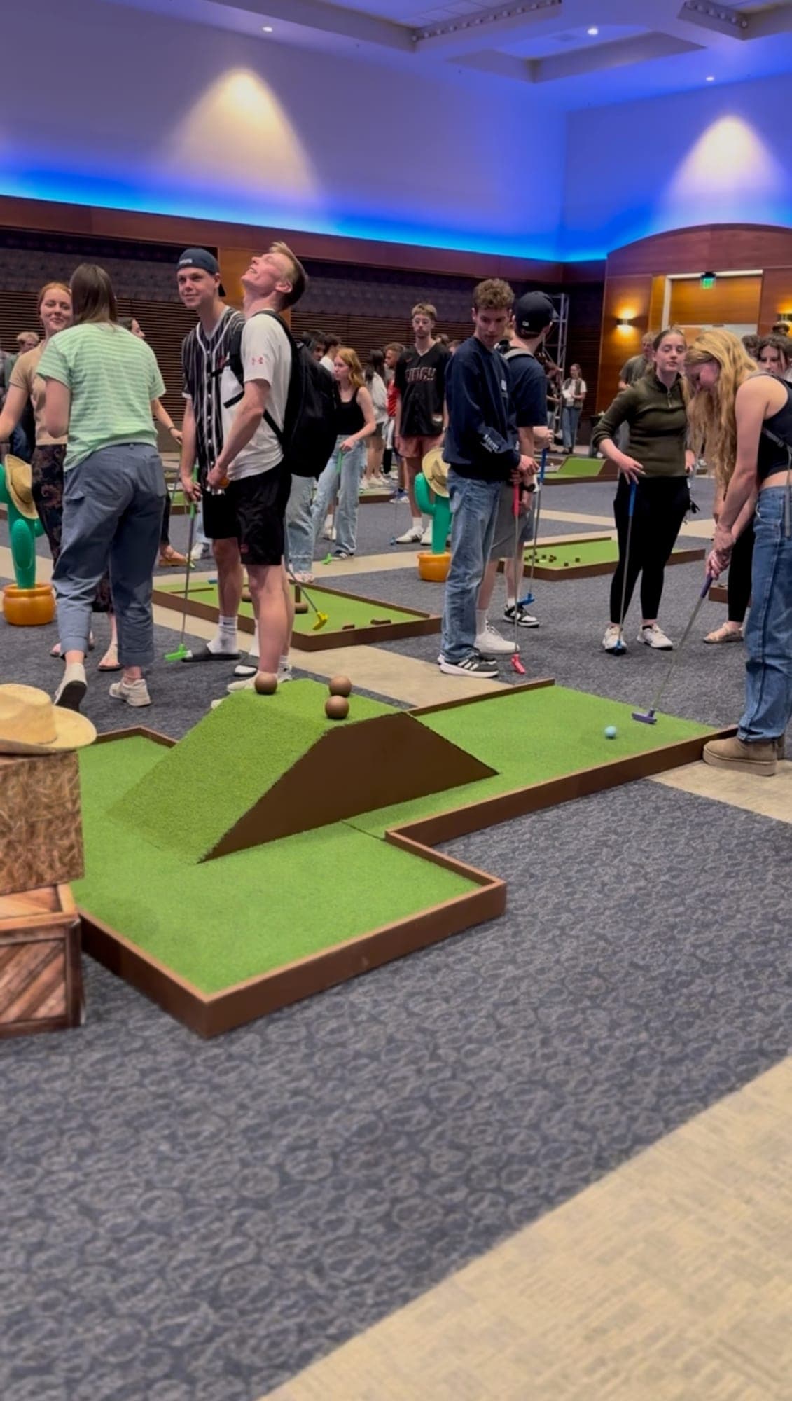 Guests gathered around an indoor Putts hole