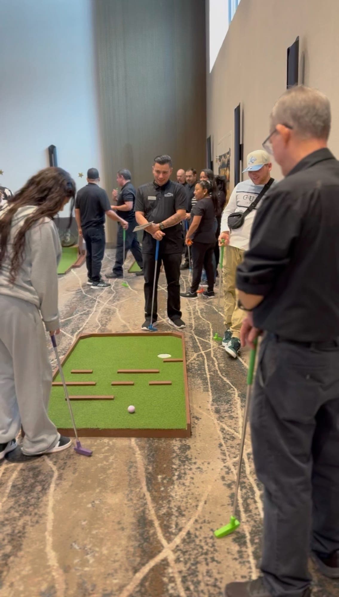 Three guests lining up putts